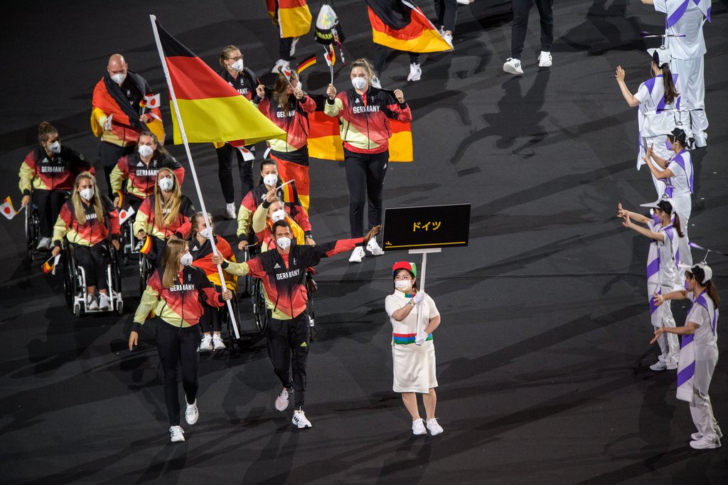 Mehrere Menschen in schwarz-rot-goldener Kleidung. Einige von ihnen tragen Deutschland-Fahnen.